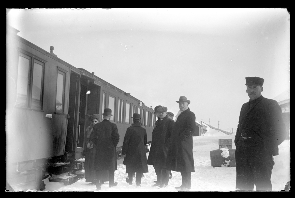 Personer foran tog på vinteren