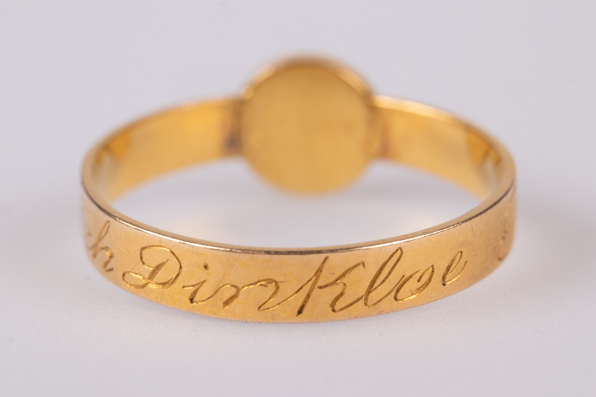 16 karats gullring med navnet "Hendrich Dinkloe Bruun" inngravert på utsiden. Ringen har hele seks mindre stempler på innsiden. I stedet for en edelstein har man i innfatningen plassert en liten perle laget av menneskehår. På toppen av denne er det montert en liten blomst med blå kronblader som ser ut til å kanskje være laget av harpiks
