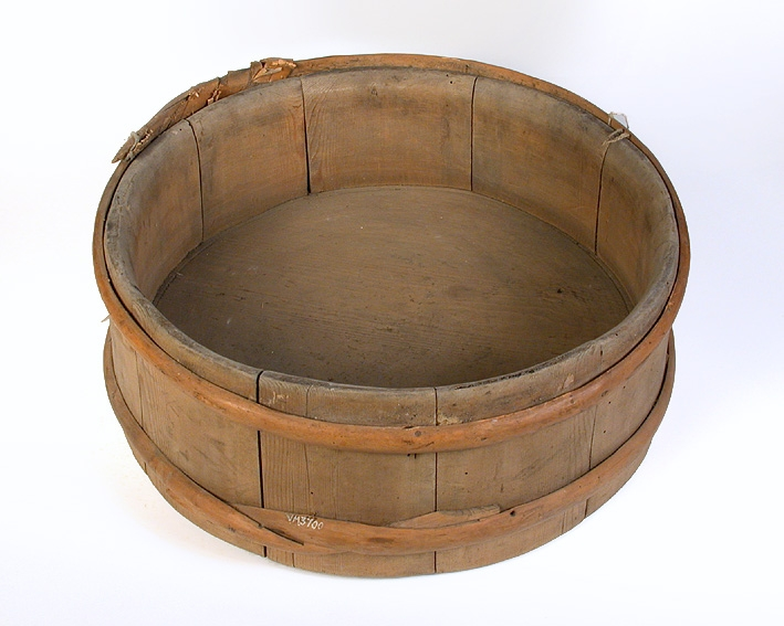 Laggkärl, bestående av en omålad cirkelformad bunke utan lock, hophållen av vidjor.