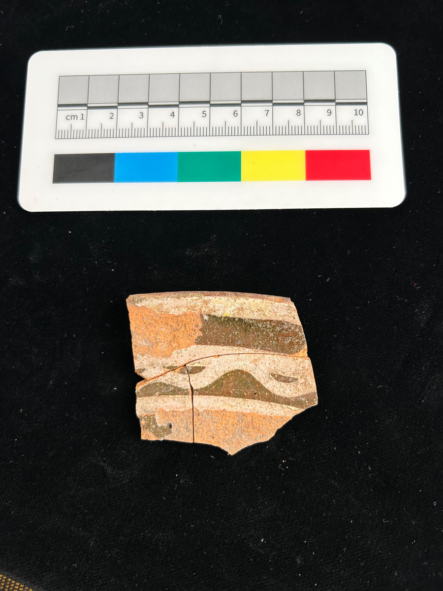 Tre fragment av fat i yngre rödgods. Bitarna har passning. Brun glasyr med gula cirklar och "vågband"