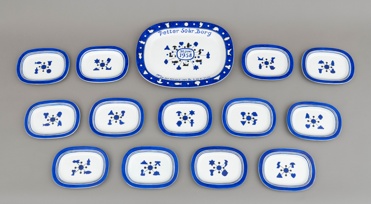 Servise av keramikk i 14 deler: 1 fat og 13 asjetter. Fat og asjetter har blå dekor med innslag av svart på hvit bunn. Alle deler er dekorert med tømmermerker, som er knyttet til eierens arbeide som tømmermåler. Tømmermerkene, figurøksenes merker, er hovedelementet i dekoren. Disse merkene ble hogd inn av tømmermålere i yteveden på tømmerstokken før fløting. Eggen på øksene hadde profiler som dannet symboler (merker) i veden. Symbolene (merkene) var knyttet til bestemte tømmerkjøpere: sagbrukseiere, telasthandlere og treforedlingsbedrifter. Øksa ble brukt da tømmeret ble solgt fra skogeier til tømmerkjøper. Det er et "sett" med 21 forskjellige symboler som brukes på fat og asjetter. Hver asjett har fire tømmermerker, mens fatet har 14 på midten og 14 langs kanten. Serviset er spesiallaget på bestilling. Det er keramikeren William Knutzen (1913-1983) som har stått føre utformingen av fat og asjetter. Han var blant annet kjent for å bruke blå dekor, som vi også ser på dette serviset. 


1 ovalt, tilnærmet rektangulært, serveringsfat: Fatet er dekorert med tømmermerker langs kanten og midt på. [Signatur er beskrevet i feltet påført tekst/merker]

13 ovale, tilnærmet rektangulære, asjetter: Asjettene har noe ulike mål, men de er cirka 22 centimeter lange og 16 centimeter brede.  [Det er satt opp mål for en av asjettene i hovedskjema, mål på øvrige asjetter gjennfinnes på underskjemaer for hver enkelt del av serviset.]