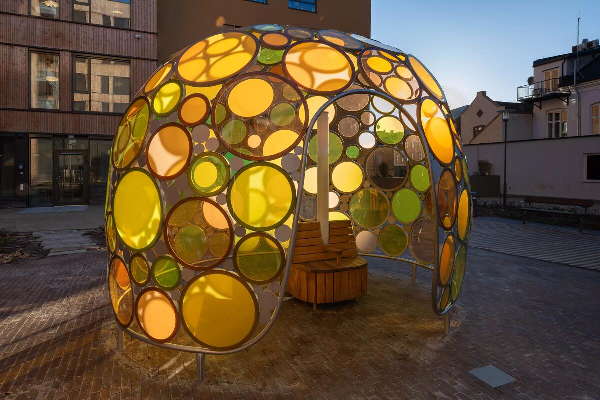 Skulpturen består av et metallskjelett som huser sirkulære glassformer i ulike fargesjatteringer. En benk er plassert inne i skulpturen slik at man kan sitte og betrakte omverden gjennom det fargede glasset. En lysstolpe i skulpturen gjør at den lyser opp når det er mørkt. 