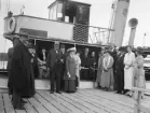 Prominenta passagerare har precis anlänt Kåreholm på Vikbolandet. Bilden är daterad 1923 och sannolikt påträffas i bilden greveparet Hakon och Andréa Mörner. Vid tiden disponerade de närmare bestämt herrgården, som för övrigt ägdes av sterbhuset till Louise Mörner. Bland de resande kan man under alla omständigheter uppfatta grevinnan Ebba Mörner till Thorönsborg. Orsaken till sammankomsten kan vi här endast spekulera kring. Möjligtvis önskade sällskapet manifestera att det gått 100 år sedan godsets huvudbyggnad stod färdig.