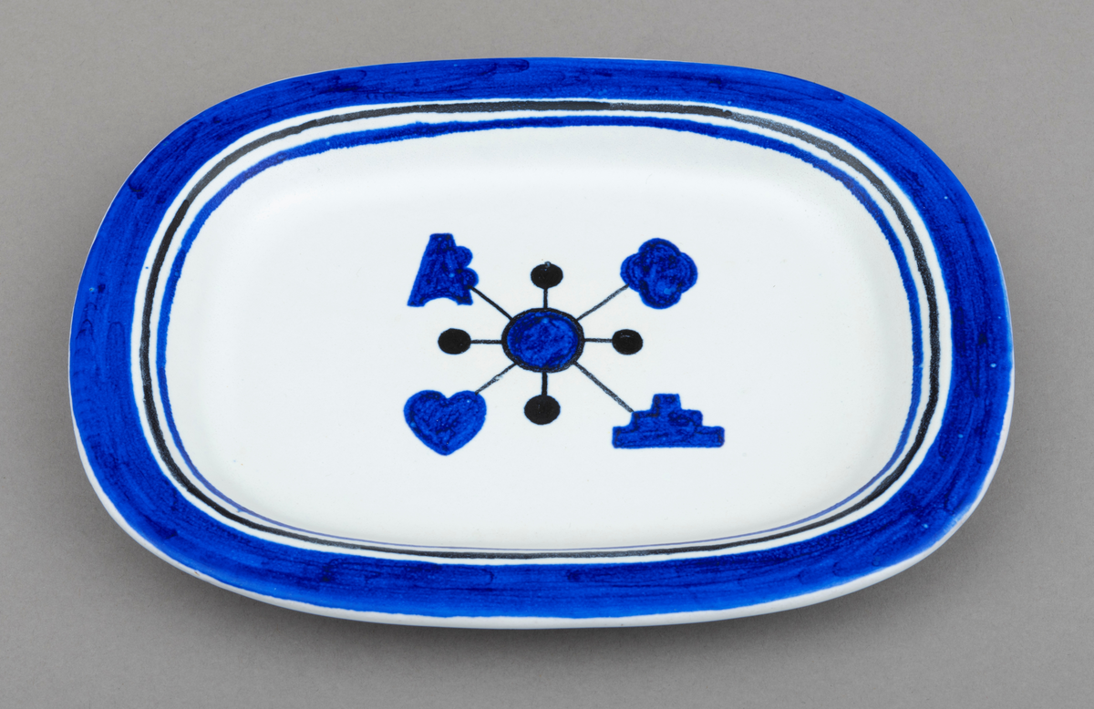 Servise av keramikk i 14 deler: 1 fat og 13 asjetter. Fat og asjetter har  blå dekor med innslag av svart på hvit bunn. Alle deler er dekorert med tømmermerker, som er knyttet til eierens arbeide som tømmermåler. Settet (serviset) er spesiallaget på bestilling. Arbeidet med serviset er utført av keramikeren William Knutzen. Han var blant annet kjent for å bruke blå dekor, som vi også ser på dette serviset. 

Dette skjemaet omhandler en av de 13 asjettene som er med  i serviset: Asjetten er oval, tilnærmet rektangulær.  Hver enkelt asjett har litt ulike mål, men de er cirka 22 centimeter lange og 16 centimeter brede. Asjetten er dekorert med en blå sirkel midt på. Ut fra sirkelen er det trukket fire svarte linjer. I enden av hver linje gjenfinnes et tømmermerke. Rundt den blå sirkelen er det trukket en en svart smal linje. Ut fra dennne linja er det trukket fire korte linjer som ender opp i en svart kule. Dekorfeltet midt på asjetten har en størrelse på cirka 7,5 cm x 6 cm. Langs kanten på asjetten er det ytterst et blått felt som er cirka 1, 5 centimeter bredt. Under dette feltet er asjetten dekorert med to tynne linjer, en svart og en blå, som er cirka 3 millimeter brede. Mellom de blå og svarte linjene, er det hvite åpne felt. Tilsammen har dekoren langs kanten på asjetten en bredde på cirka 2,5 centimeter.

Av de fire tømmermerkene (tømmerkjøperne) som er representert på asjetten er fire av dem identifisert. Det er brukt merkekart for Glomma Fellesfløtingsforening fra 1956 som utgangspunkt for identifiseringen:
Merke plassert øverst til venstre: And. H. Kiær & Co. Ltd.  (nr. 68 på kart)   
Merke plassert øverst til høyre:  A/S Skurtømmer (nr. 161 på kart)
Merke plassert nederst  til venstre:  Hans Aaraas (nr. 165 på kart)
Merke plassert nederst til høyre: Hurum Fabriker (nr. 104  på kart)