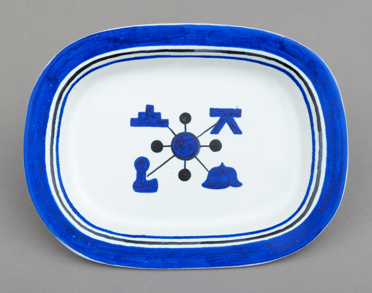 Servise av keramikk i 14 deler: 1 fat og 13 asjetter. Fat og asjetter har  blå dekor med innslag av svart på hvit bunn. Alle deler er dekorert med tømmermerker, som er knyttet til eierens arbeide som tømmermåler. Settet (serviset) er spesiallaget på bestilling. Arbeidet med serviset er utført av keramikeren William Knutzen. Han var blant annet kjent for å bruke blå dekor, som vi også ser på dette serviset. 

Dette skjemaet omhandler en av de 13 asjettene som er med  i serviset: Asjetten er oval, tilnærmet rektangulær.  Hver enkelt asjett har litt ulike mål, men de er cirka 22 centimeter lange og 16 centimeter brede. Asjetten er dekorert med en blå sirkel midt på. Ut fra sirkelen er det trukket fire svarte linjer. I enden av hver linje gjenfinnes et tømmermerke. Rundt den blå sirkelen er det trukket en en svart smal linje. Ut fra dennne linja er det trukket fire korte linjer som ender opp i en svart kule. Dekorfeltet midt på asjetten har en størrelse på cirka 7,5 cm x 6 cm. Langs kanten på asjetten er det ytterst et blått felt som er cirka 1, 5 centimeter bredt. Under dette feltet er asjetten dekorert med to tynne linjer, en svart og en blå, som er cirka 3 millimeter brede. Mellom de blå og svarte linjene, er det hvite åpne felt. Tilsammen har dekoren langs kanten på asjetten en bredde på cirka 2,5 centimeter.

Av de fire tømmermerkene (tømmerkjøperne) som er representert på asjetten er fire av dem identifisert. Det er brukt merkekart for Glomma Fellesfløtingsforening fra 1956 som utgangspunkt for identifiseringen for tre av dem og kart fra 1838 for ett merke:
Merke plassert øverst til venstre: Hurum Fabriker (nr. 104 på kart)   
Merke plassert øverst til høyre: ikke identifisert på kart fra 1956, men tilhørende N. J. Ytteborg på kart fra 1838. 
Merke plassert nederst  til venstre: Sande Tresliperi A/S  (nr. 173 på kart)
Merke plassert nederst til høyre: Bernt Paulsen  (nr. 239 på kart)