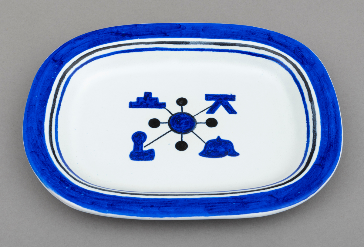 Servise av keramikk i 14 deler: 1 fat og 13 asjetter. Fat og asjetter har  blå dekor med innslag av svart på hvit bunn. Alle deler er dekorert med tømmermerker, som er knyttet til eierens arbeide som tømmermåler. Settet (serviset) er spesiallaget på bestilling. Arbeidet med serviset er utført av keramikeren William Knutzen. Han var blant annet kjent for å bruke blå dekor, som vi også ser på dette serviset. 

Dette skjemaet omhandler en av de 13 asjettene som er med  i serviset: Asjetten er oval, tilnærmet rektangulær.  Hver enkelt asjett har litt ulike mål, men de er cirka 22 centimeter lange og 16 centimeter brede. Asjetten er dekorert med en blå sirkel midt på. Ut fra sirkelen er det trukket fire svarte linjer. I enden av hver linje gjenfinnes et tømmermerke. Rundt den blå sirkelen er det trukket en en svart smal linje. Ut fra dennne linja er det trukket fire korte linjer som ender opp i en svart kule. Dekorfeltet midt på asjetten har en størrelse på cirka 7,5 cm x 6 cm. Langs kanten på asjetten er det ytterst et blått felt som er cirka 1, 5 centimeter bredt. Under dette feltet er asjetten dekorert med to tynne linjer, en svart og en blå, som er cirka 3 millimeter brede. Mellom de blå og svarte linjene, er det hvite åpne felt. Tilsammen har dekoren langs kanten på asjetten en bredde på cirka 2,5 centimeter.

Av de fire tømmermerkene (tømmerkjøperne) som er representert på asjetten er fire av dem identifisert. Det er brukt merkekart for Glomma Fellesfløtingsforening fra 1956 som utgangspunkt for identifiseringen for tre av dem og kart fra 1838 for ett merke:
Merke plassert øverst til venstre: Hurum Fabriker (nr. 104 på kart)   
Merke plassert øverst til høyre: ikke identifisert på kart fra 1956, men tilhørende N. J. Ytteborg på kart fra 1838. 
Merke plassert nederst  til venstre: Sande Tresliperi A/S  (nr. 173 på kart)
Merke plassert nederst til høyre: Bernt Paulsen  (nr. 239 på kart)