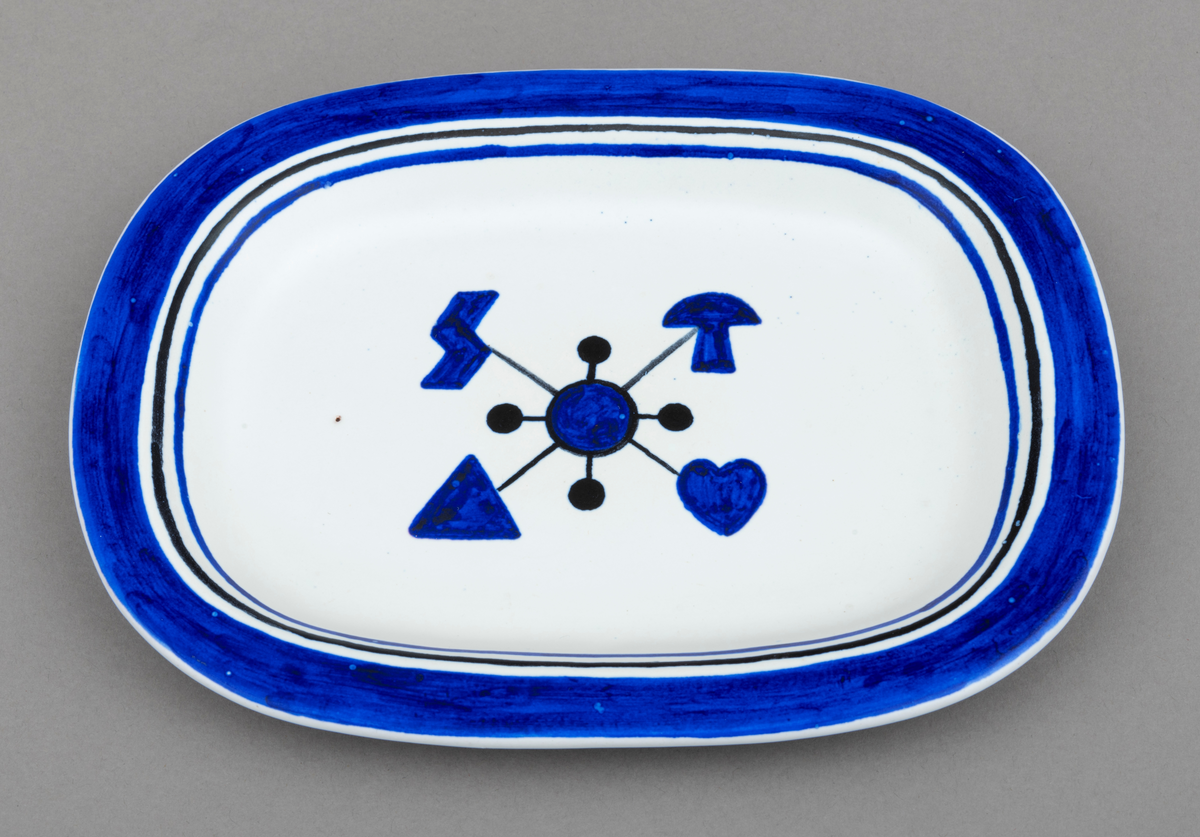 Servise av keramikk i 14 deler: 1 fat og 13 asjetter. Fat og asjetter har  blå dekor med innslag av svart på hvit bunn. Alle deler er dekorert med tømmermerker, som er knyttet til eierens arbeide som tømmermåler. Settet (serviset) er spesiallaget på bestilling. Arbeidet med serviset er utført av keramikeren William Knutzen. Han var blant annet kjent for å bruke blå dekor, som vi også ser på dette serviset. 

Dette skjemaet omhandler en av de 13 asjettene som er med  i serviset: Asjetten er oval, tilnærmet rektangulær.  Hver enkelt asjett har litt ulike mål, men de er cirka 22 centimeter lange og 16 centimeter brede. Asjetten er dekorert med en blå sirkel midt på. Ut fra sirkelen er det trukket fire svarte linjer. I enden av hver linje gjenfinnes et tømmermerke. Rundt den blå sirkelen er det trukket en en svart smal linje. Ut fra dennne linja er det trukket fire korte linjer som ender opp i en svart kule. Dekorfeltet midt på asjetten har en størrelse på cirka 7,5 cm x 6 cm. Langs kanten på asjetten er det ytterst et blått felt som er cirka 1, 5 centimeter bredt. Under dette feltet er asjetten dekorert med to tynne linjer, en svart og en blå, som er cirka 3 millimeter brede. Mellom de blå og svarte linjene, er det hvite åpne felt. Tilsammen har dekoren langs kanten på asjetten en bredde på cirka 2,5 centimeter.

Av de fire tømmermerkene (tømmerkjøperne) som er representert på asjetten er tre av dem identifisert. Det er brukt merkekart for Glomma Fellesfløtingsforening fra 1956 som utgangspunkt for identifiseringen:
Merke plassert øverst til venstre: Wilhelm Staer  (nr. 29  på kart)   
Merke plassert øverst til høyre:  Torp Brugs Akitieselskab (nr. 222 på kart)
Merke plassert nederst  til venstre: Ankers Træsliperi  (nr. 199  på kart)
Merke plassert nederst til høyre: ikke identifisert  (nr.  på kart)