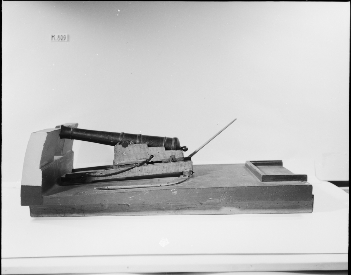 Kanonmodell: 24-pundig svänglåda med kanon för skeppet Wasa, av Chapmans Titz modell. Modellen helt av trä. Kanonen svartbetad, lådan fernissad. Lavetten L = 635 mm B = 370 mm H = 295 mm.