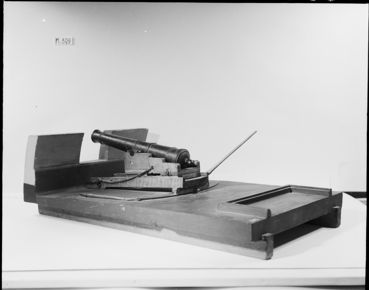 Kanonmodell: 24-pundig svänglåda med kanon för skeppet Wasa, av Chapmans Titz modell. Modellen helt av trä. Kanonen svartbetad, lådan fernissad. Lavetten L = 635 mm B = 370 mm H = 295 mm.