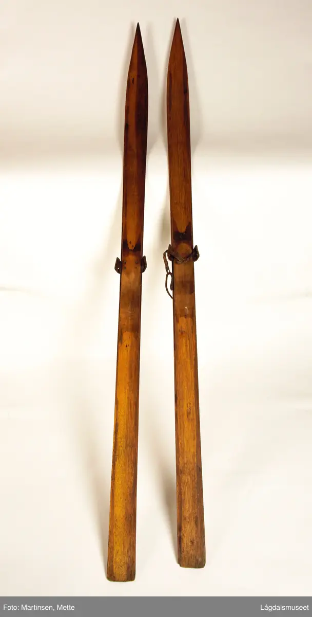 Et par treski. Midt på, på hver side, jernbelegg til binding. Den ene skien (merket Lm 961a) en liten del av lærreim til binding.
