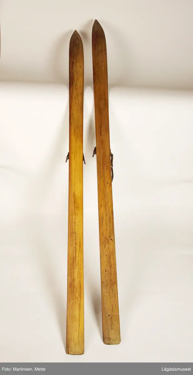 Et par treski. Midt på, på hver side, jernbelegg til binding. Den ene skien (merket Lm 961a) en liten del av lærreim til binding.