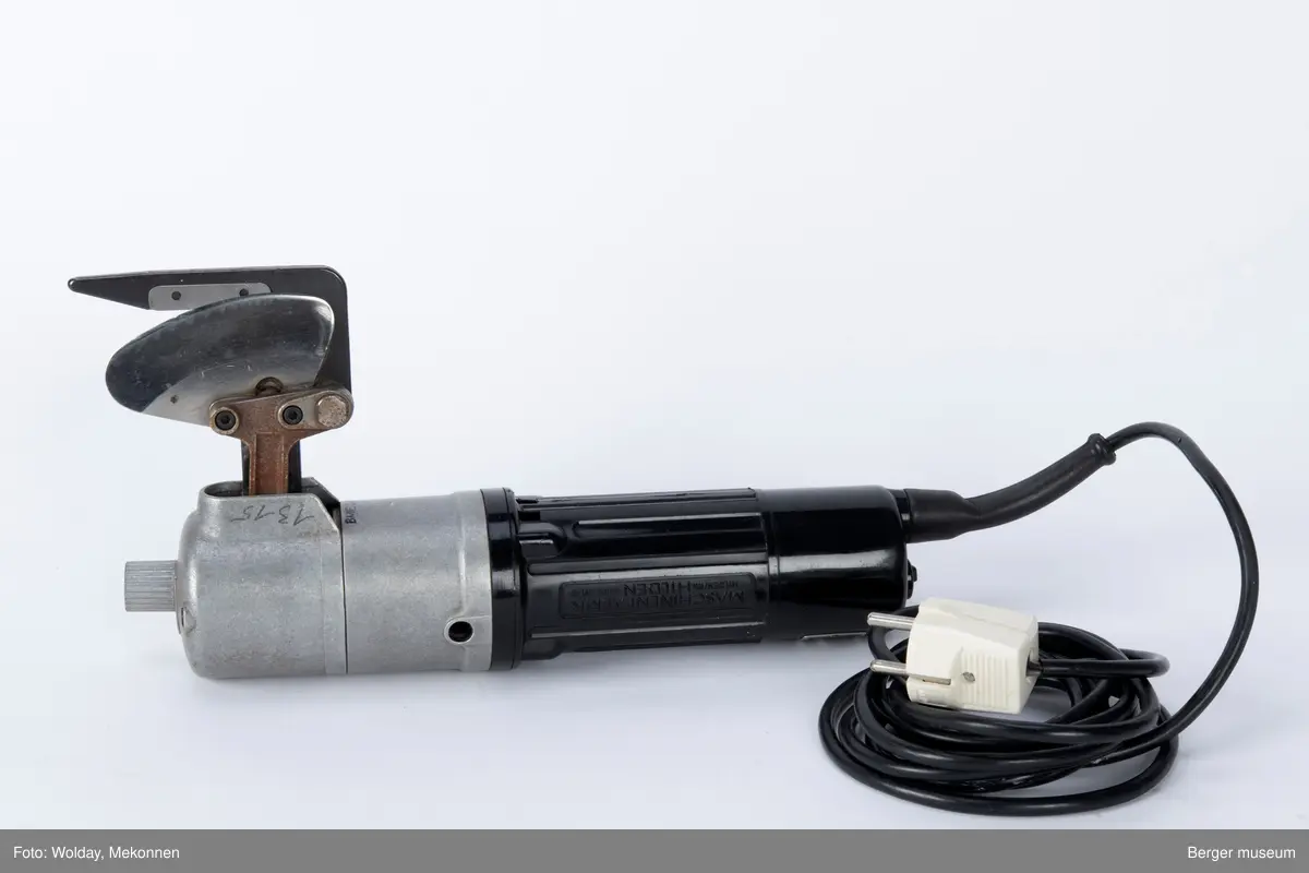 Sylinderformet hoevdkropp, med et klippeblad på nedsiden foran. Motordelen bak, med plastdeksel, fremre halvdel i metall. Elektrisk ledning med stikk.