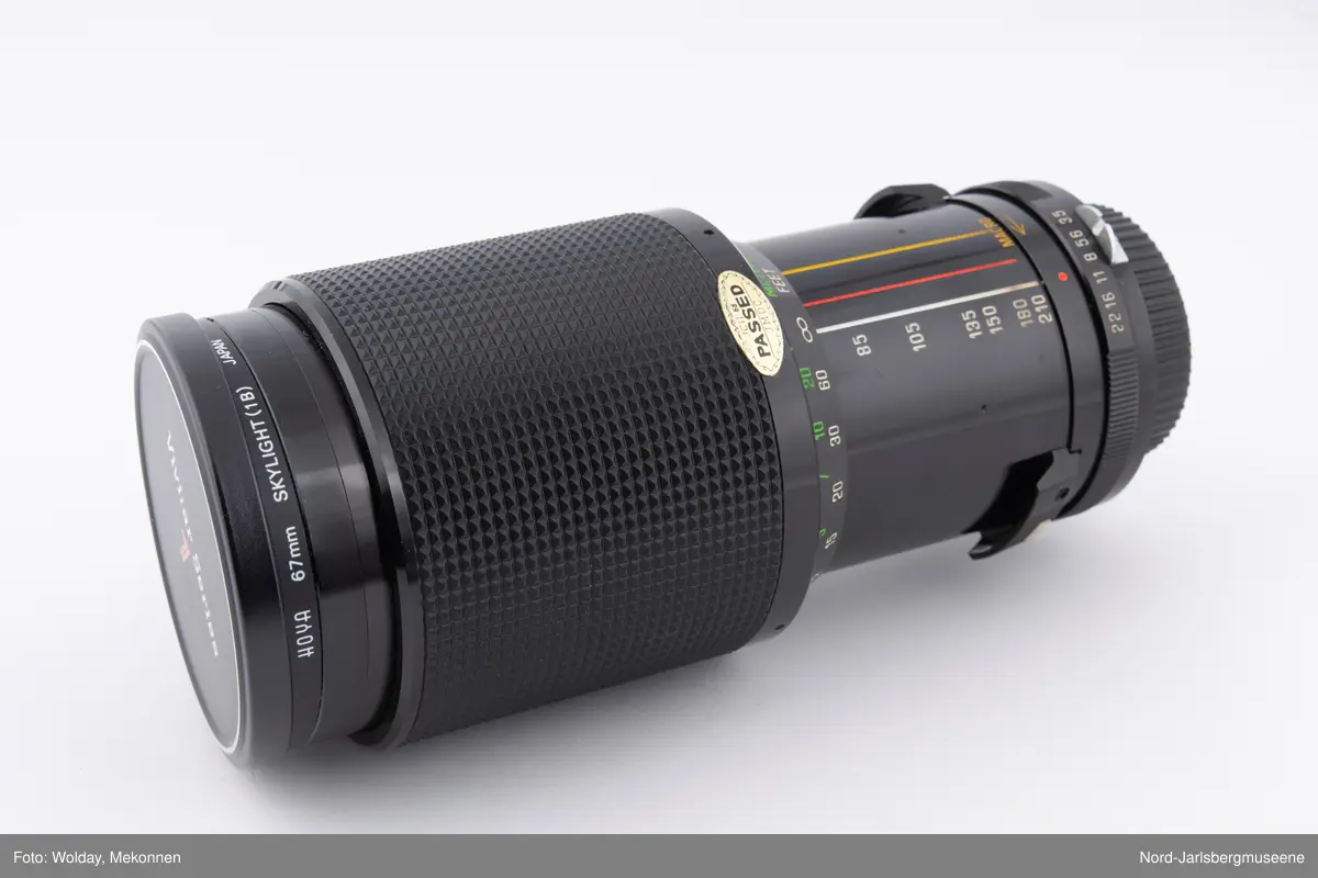 67 mm objektiv med et sylinderformet etui.
