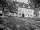 Amatörfotografi mot huvudbyggnaden till Vi säteri (även Wij) vid sjön Glans strand öster om Norrköping. Herrgården uppfördes sannolikt i början av 1800-talet men ombyggdes radikalt 1910 genom kapten Karl Fredrik von Malmborgs försorg, som själv utförde ritningarna.