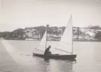 Segelkanot på Djurgårdsbrunnsviken. I bakgrunden det snötäckta Skansenberget med Bredablick.