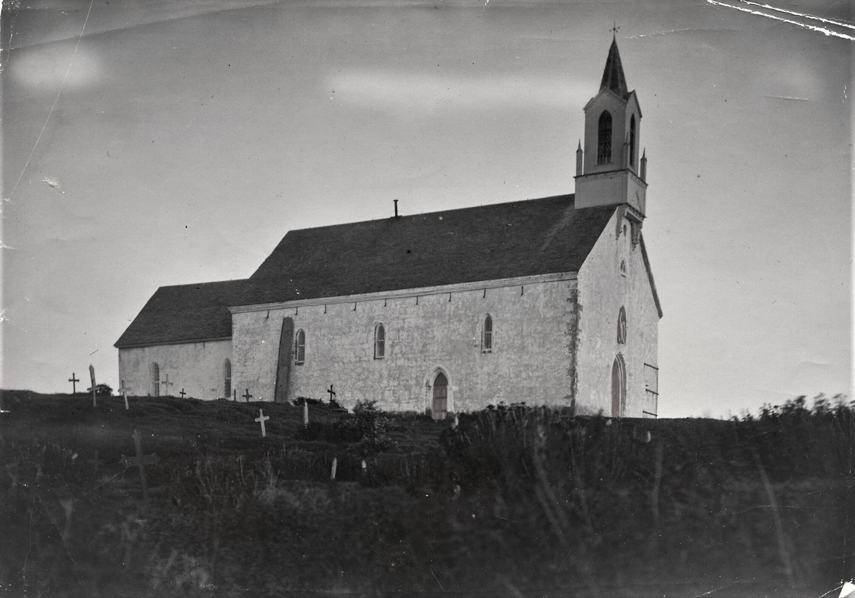 Olavskirka på Avaldsnes sett fra nordvest. Jomfru Marias synål heller mot nordveggen. Bildet er lett retusjert over dører og noen detaljer, samt skyer på himmelen. Klokketårnet fra 1862 viser at bildet tatt før restaureringen av steintårnet, som stod ferdig i 1929.