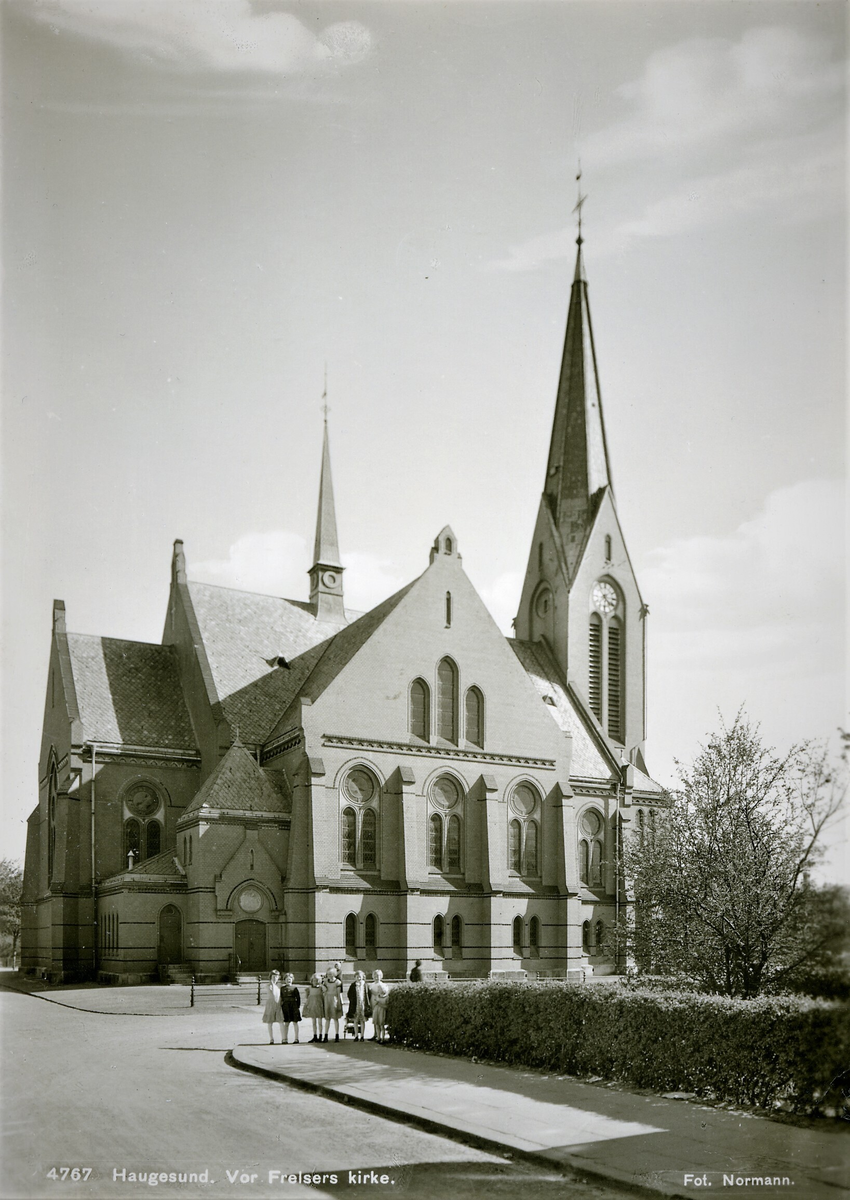 Vår Frelsers kirke i Haugesund, sett fra nord. En gruppe barn står i krysset mellom Johan Thorsens gate og Kirkegata.