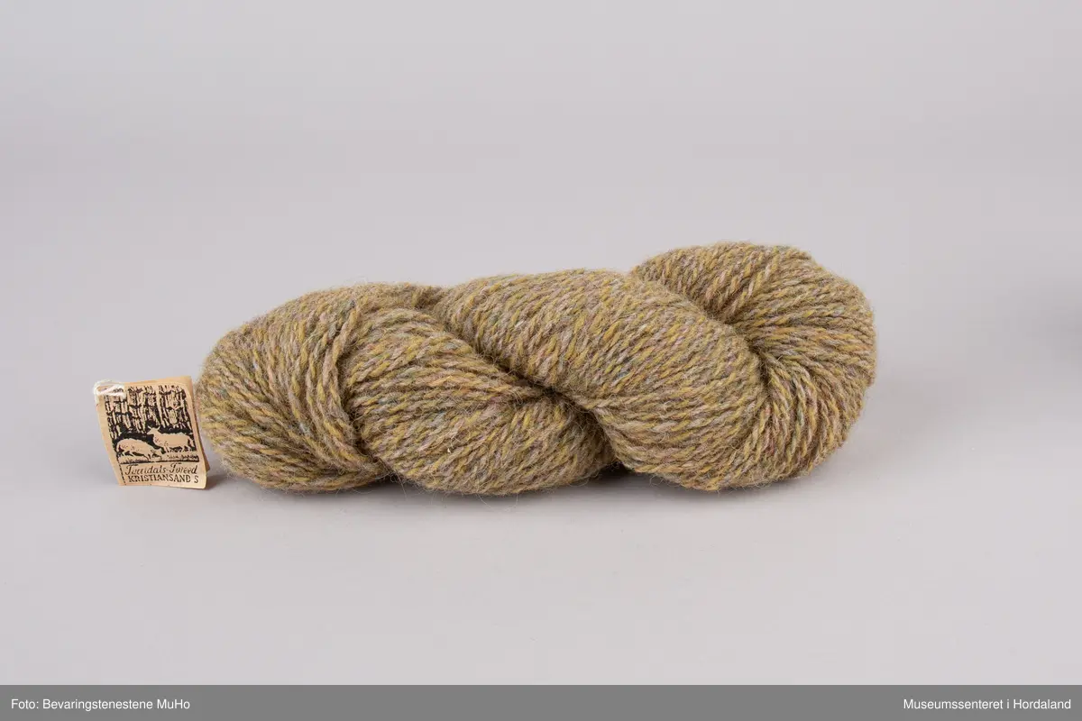 Hespe med ullgarn i brune/beige sjatteringar.