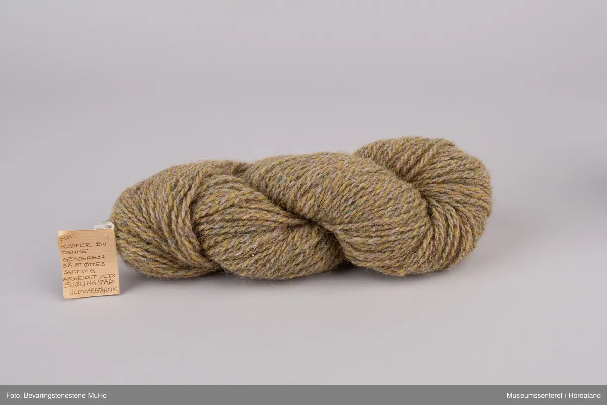 Hespe med ullgarn i brune/beige sjatteringar.