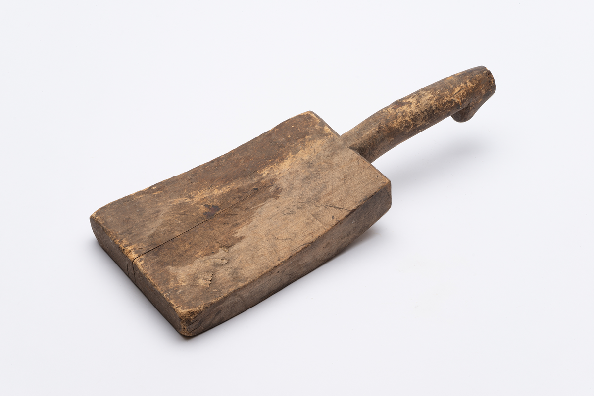 Rektangulært avsmalnende banketre med buet blad. Håndtak med mothake.