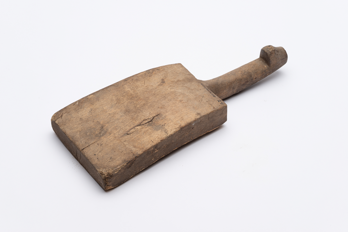 Rektangulært avsmalnende banketre med buet blad. Håndtak med mothake.