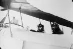 Två flygare i flygplan. I förarsits sitter Karl Illner. Österrike-Ungern, tidigt 1910-tal. Vy från sidan. Repro.