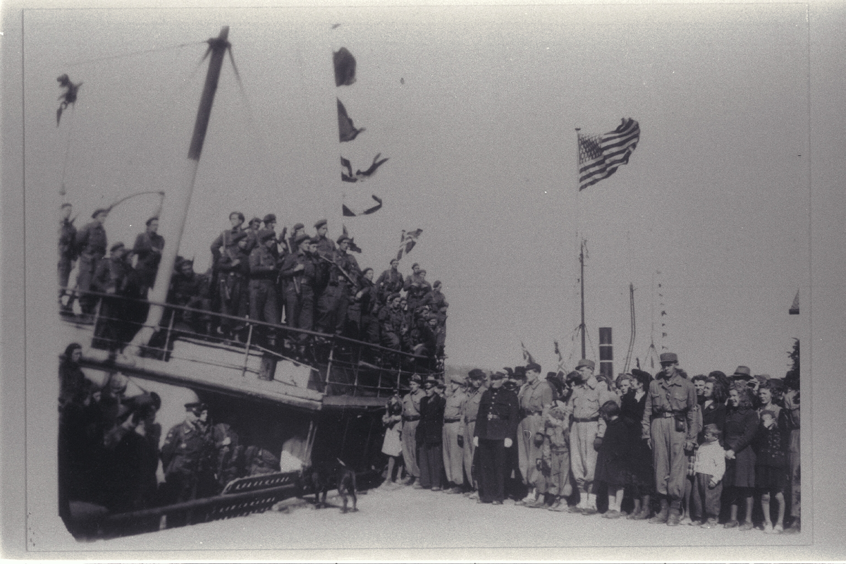 Foto av M/S Tromsø i det den har lagt til kai i Bodø og Fauske med 1 bergkompani i mai 1945.
