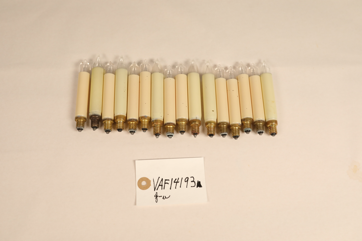 Utstillingsfigur montert på plate. Figuren er utformet som et reinsdyr i hvitt, silkeaktig stoff med brune klover og filtøyne. Geviret er surret inn med gullbånd og har sokler til lyspærer i taggene. Geviret er avtagbart. Reinsdyret har seletøy i rosa og lilla filt med gulltråd og runde metallplater. Juletrelysene til geviret er Philips 14v. Det stikker ender av ledninger ut av både kroppen og geviret. 

Reinsdyret består av flere deler:
a - kropp montert på plate med metallstøtte foran og bena skrudd fast bak. På et tidspunkt har noen stiftet fast papir over ytterkantene av det originalet stoffet.
b - gevir med plass til 8 lyspærer
c - gevir med plass til 7 lyspærer
d - løs pyntedusk
e - grå ledning
f til u - 16 lyspærer