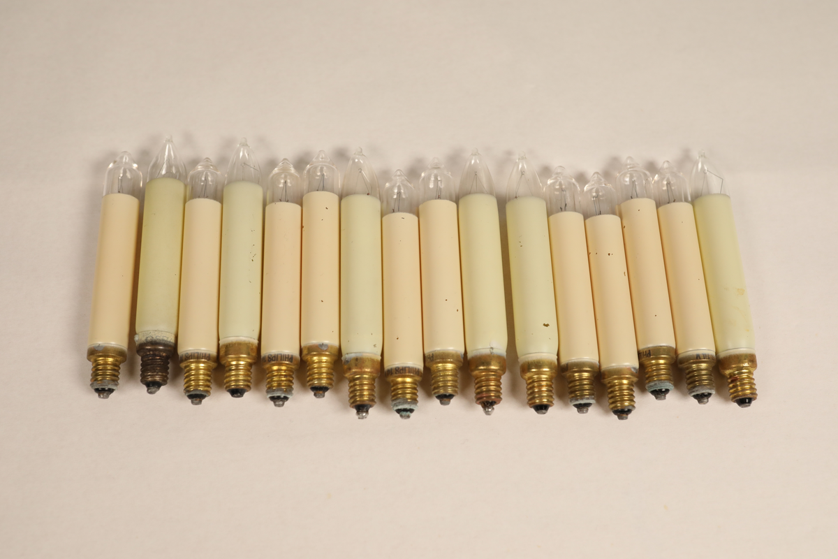 Utstillingsfigur montert på plate. Figuren er utformet som et reinsdyr i hvitt, silkeaktig stoff med brune klover og filtøyne. Geviret er surret inn med gullbånd og har sokler til lyspærer i taggene. Geviret er avtagbart. Reinsdyret har seletøy i rosa og lilla filt med gulltråd og runde metallplater. Juletrelysene til geviret er Philips 14v. Det stikker ender av ledninger ut av både kroppen og geviret. 

Reinsdyret består av flere deler:
a - kropp montert på plate med metallstøtte foran og bena skrudd fast bak. På et tidspunkt har noen stiftet fast papir over ytterkantene av det originalet stoffet.
b - gevir med plass til 8 lyspærer
c - gevir med plass til 7 lyspærer
d - løs pyntedusk
e - grå ledning
f til u - 16 lyspærer