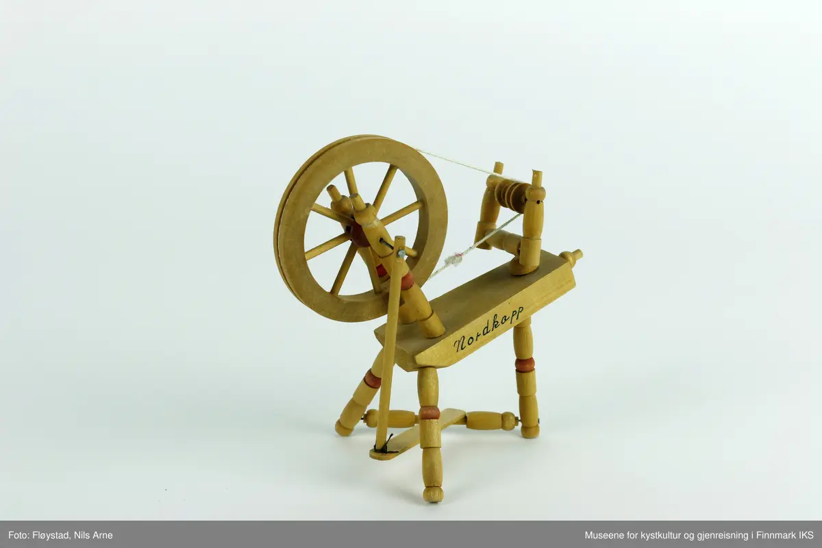 En hjulrokk på størrelse med et dukkehusmøbel i utforming fra 1800-tallet. Rokken har skrått bryst, tre bein, et hjul med 8 eiker, to like jomfruer og en skrue i enden av brystet. Hjulet spinnes med ei trøe og en veiv. Alle delene er antakeligvis håndlaget, eller skjært ut med bruk av en dreiebenk og deretter limt sammen. 

På den ene siden av brystet er det skrevet "Nordkapp" i sort. Naven på rokken er malt rød. Beinene og oppstanderne på rokken har dreide kuler, som også er malt rød.

Rokken ble solgt som suvenir i Nordkapphallen engang på 1970-tallet.