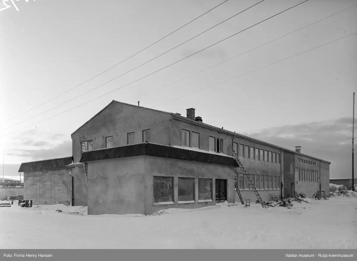 Nord-Norges Salgslag, Vadsø i januar 1957. Nord-Norges Salgslag ble bygget i 1956; arkitekt Kjell Magne Olsen og hovedentreprenør Rolf Bohinen.