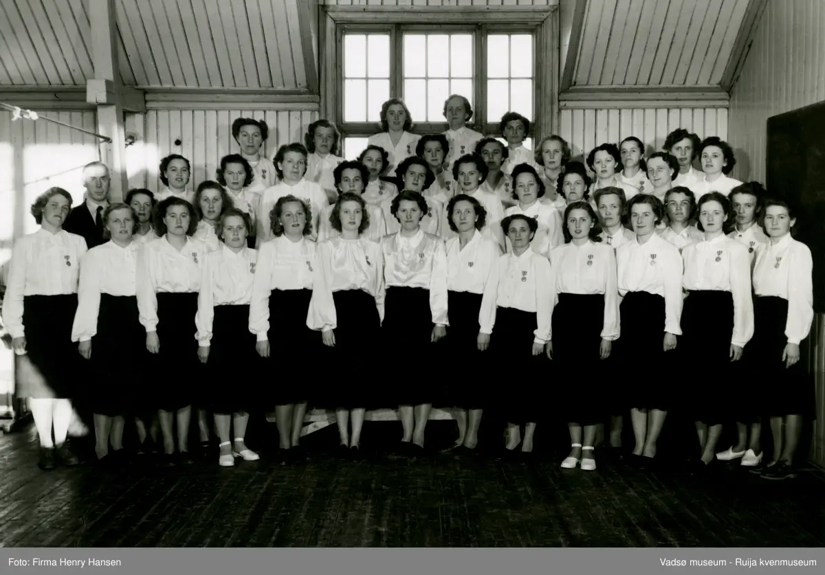 Vadsø Damekor 1950. Damekoret er samlet i 2.etasje på den gamle gymnastikksalen i Vadsø.
Kormedlemmer; 1 Mary Bohinen, 2 dirigent Lunde, 3 Elsa Wærnes, 4 Reidun Basma, 5 Amy Evanger, 6 Alfhild Ballo, 7 Alma Seppelæ, 8 Ragny Stock, 9 Lisbeth Esbensen, 10 Martha Hansen, 11 ukjent, 12 Mimi Zahl (Jørgensen), 13 Fru Hamborg Olsen,  14 ukjent, 15 Gerda Hoftaniska, 16 Fru (Feldt) Bjerke, 17 Karin Wærnes, 18 Ellen Helfjord, 19 Ruth Hågensen, 20 Borghild Dahl, 21 Ågot Lohiniva, 22 Fru Bohinen,  23 Hulda Onseng, 24 Klara Pedersen, 25 Torbjørg Vorren, 26 Astrid Brevik, 27 Ella Hoftaniska,  28 Bella Stock, 29 Ingrid Klemetsen, 30 Frk Eriksen, 31 Fru Haldorsen, 32 Johanna Schjetne, 33 Ruth Helfjord, 34 Sofie Klemetsen, 35 Elsa Schirnov, 36 Asbjørg Betten, 37 ukjent, 38 Randi Helander, 29 Pauline Stock, 40, Fru Aronsen, 41 ukjent, 42 Mimmi Dallavara