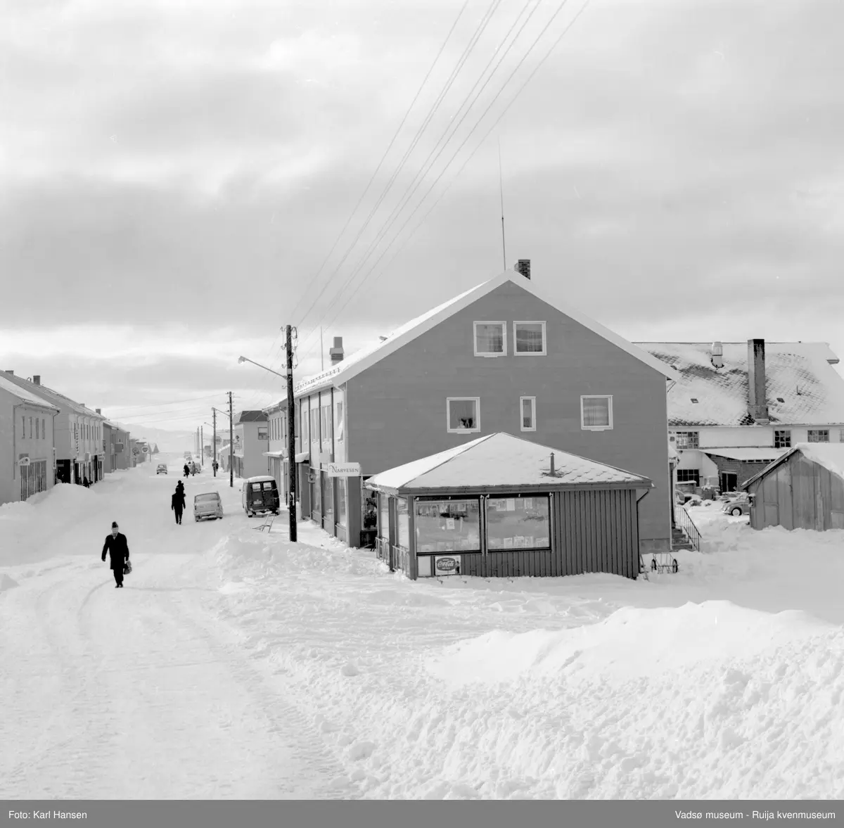 Narvesenkiosken en vinterdag i Tollbugata, Vadsø. Bildet viser Tollbugata med høye brøytekanter.  