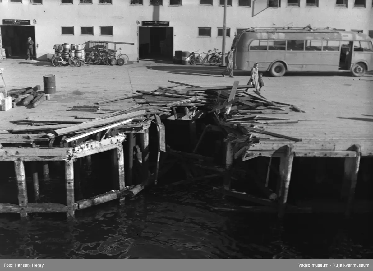 Vadsø 13 september 1951.  Torsdag 13 september 1951 gikk godsbåten  DS "Luna" tilhørende Bergenske Ds selskap med god fart inn i dampskipskaia i Vadsø. "Luna" var hele 6 meter inne i kaia før den stoppet opp. Kaidekket ble revet opp, men det ble ikke  skader på skipet. Havnefogden anslo skadene på kaia til ca 2-5000 kroner.
På kaia ser vi en buss parkert, noen sykler, tønner og oljefat langs veggen og noen personer.
Kilde: Dagbladet "Finnmarken", lørdag 15 september 1951.