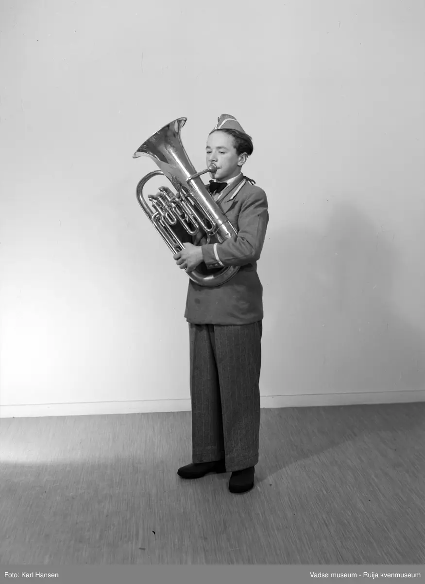 Vadsø Guttemusikkorps. Korpsdeltager med barytonhorn (?) i korpsuniform. 
