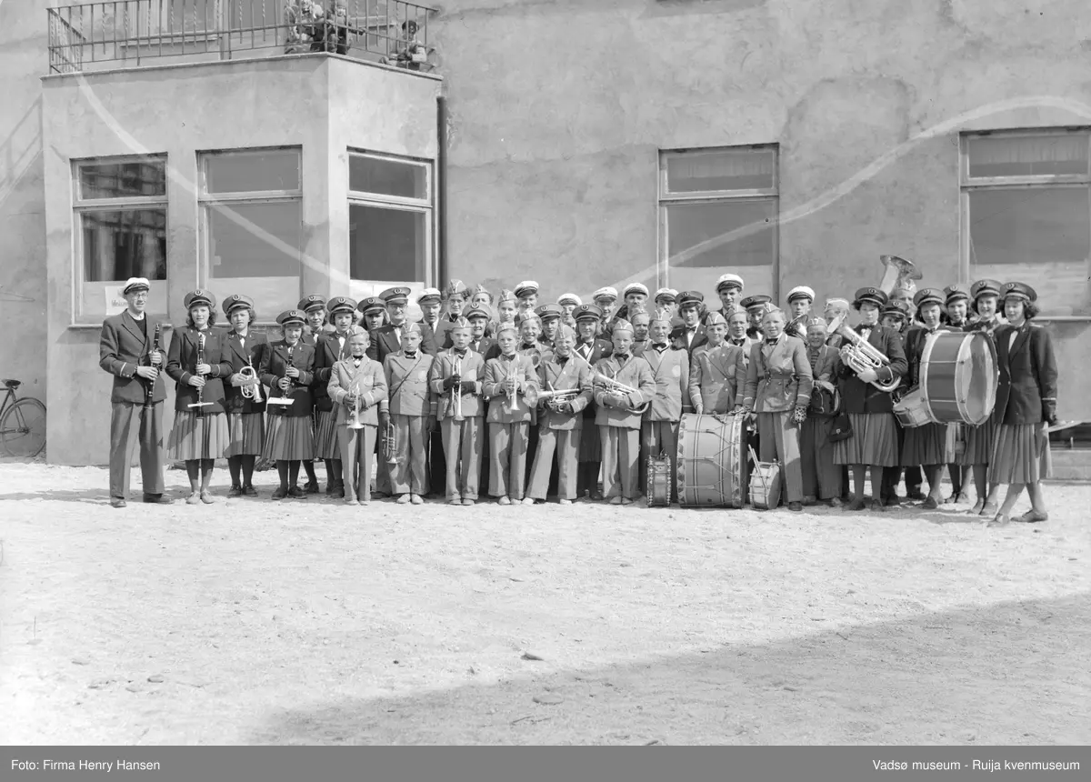 Vadsø mai 1951. Vadsø Guttemusikkorps, Vadsø Pikemusikkorps og antatt Vadsø Hornmusikkorps med dirigent Olav Holmen på torget i Vadsø.