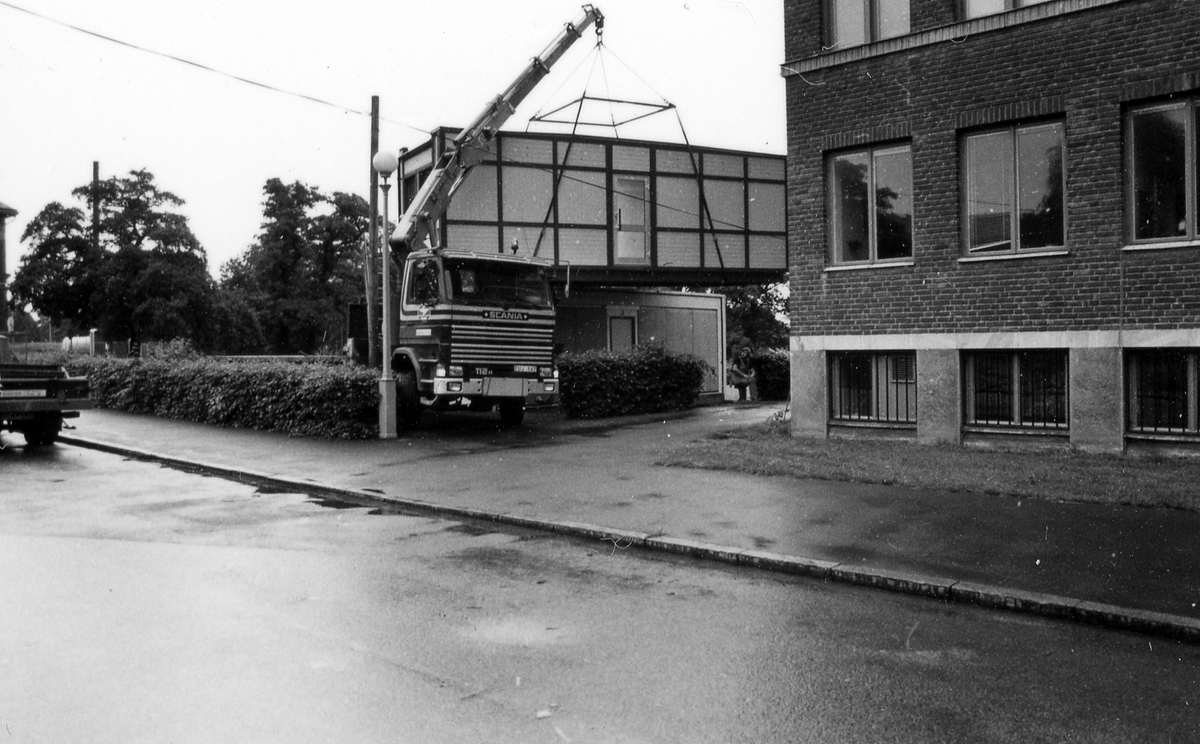 Leverans av två kontorsmoduler den 26 juni 1985.
Foto 1-2 Avvävning av marken.
Foto 3-7 Bakre modulen lyfts av med kran.
Foto 8-15 Främre modulen lyfts på plats.