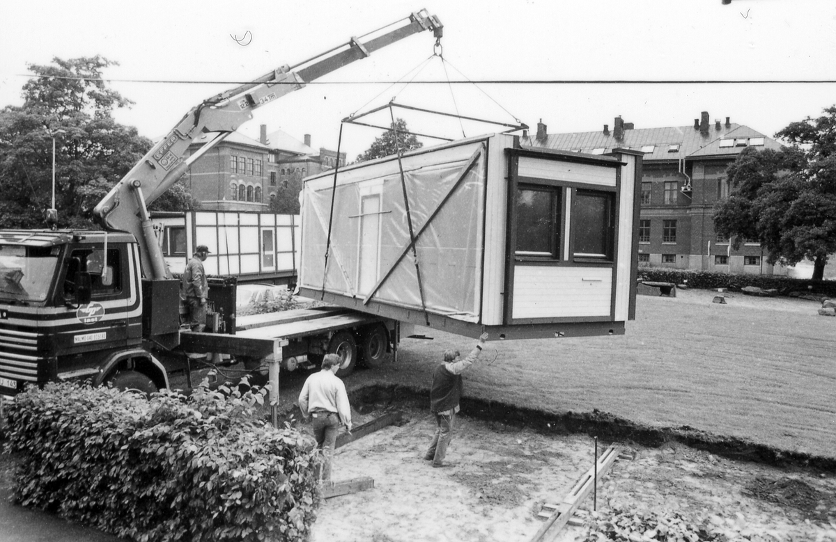 Leverans av två kontorsmoduler den 26 juni 1985.
Foto 1-2 Avvävning av marken.
Foto 3-7 Bakre modulen lyfts av med kran.
Foto 8-15 Främre modulen lyfts på plats.