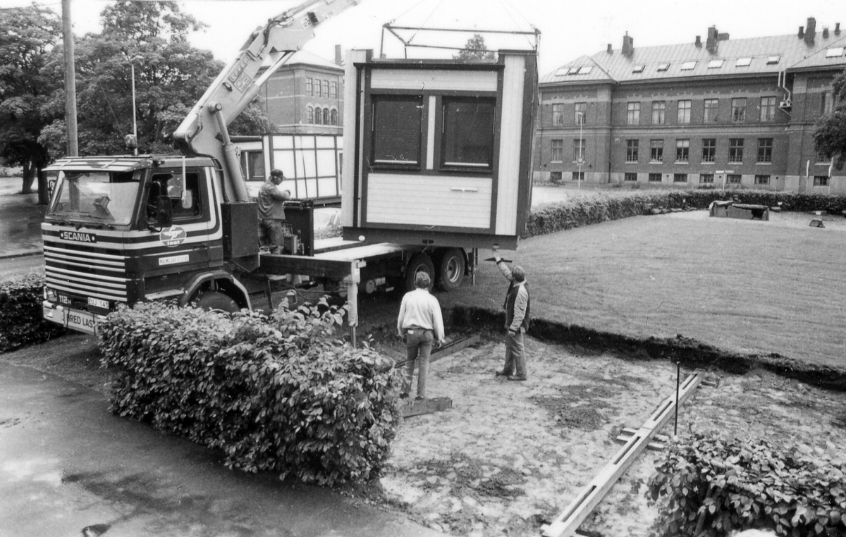 Leverans av två kontorsmoduler den 26 juni 1985.
Foto 1-2 Avvävning av marken.
Foto 3-7 Bakre modulen lyfts av med kran.
Foto 8-15 Främre modulen lyfts på plats.