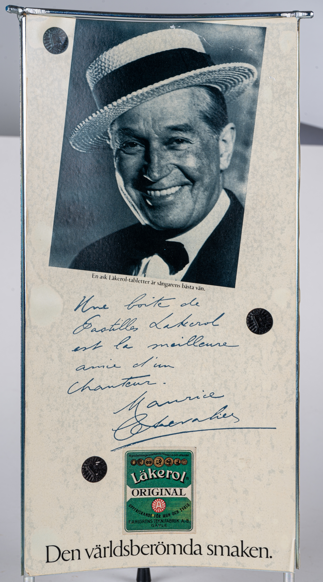 Reklamskylt, reklampelare på tre ben med plastfötter, i metall och papp, för Läkerol. Intygsreklam med citat från tre kändisar: Joséphine Baker, Ernst Rolf och Maurice Chevalier på de tre sidorna.