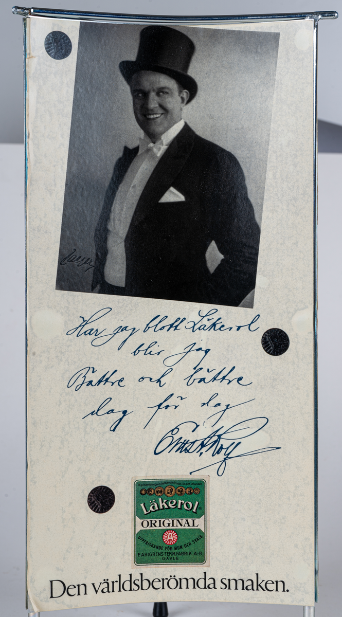 Reklamskylt, reklampelare på tre ben med plastfötter, i metall och papp, för Läkerol. Intygsreklam med citat från tre kändisar: Joséphine Baker, Ernst Rolf och Maurice Chevalier på de tre sidorna.
