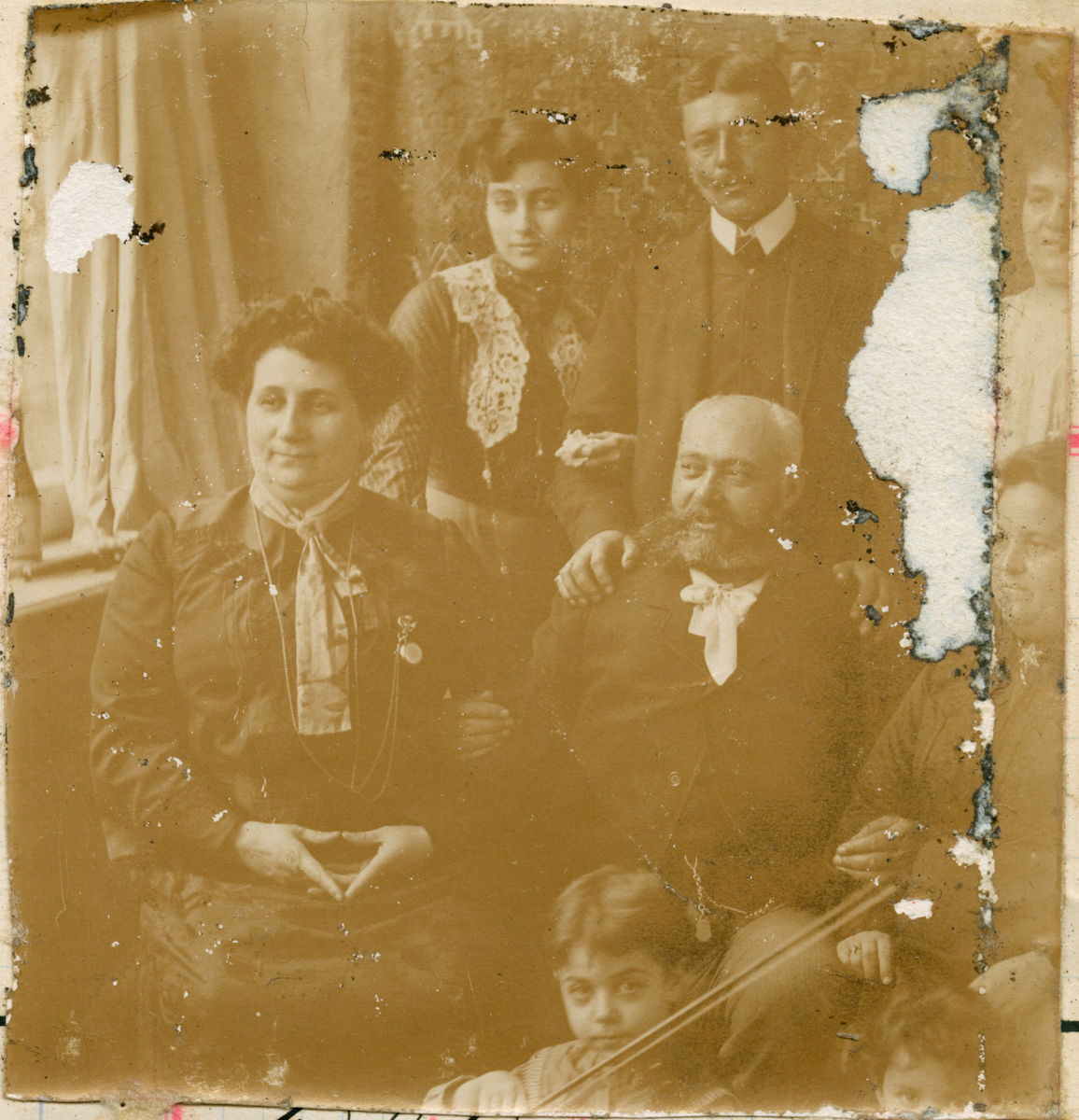Motivet viser øverste rekke, Florentine Rostin, Constantin Cebrian og hans hustru Tante Lotka - Leocadie Rostin Cebrian. Nederst: Nicolay Rostin med fiolin. Poserende foran et dekorativt veggteppe. I vinduskarmen til venstre står en flaske.