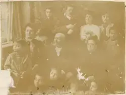 Gruppebilde av mennesker i flere aldre som poserer foran et 