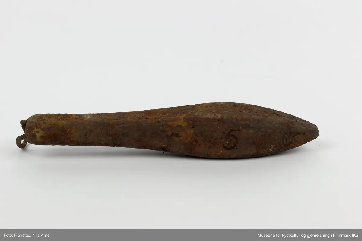 En avlang og dråpeformet jarstein med hempe. På den ene siden av jarsteinen er tallet "5" gravert, som angir vekten på steinen (500 gram).
