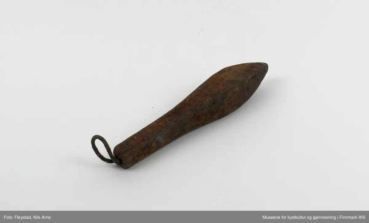En avlang og dråpeformet jarstein med hempe. På den ene siden av jarsteinen er tallet "5" gravert, som angir vekten på steinen (500 gram).