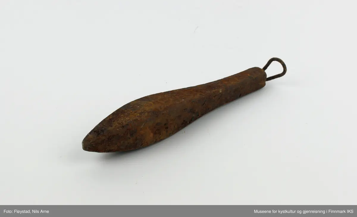 En avlang og dråpeformet jarstein med hempe. På den ene siden av jarsteinen er tallet "5" gravert, som angir vekten på steinen (500 gram).