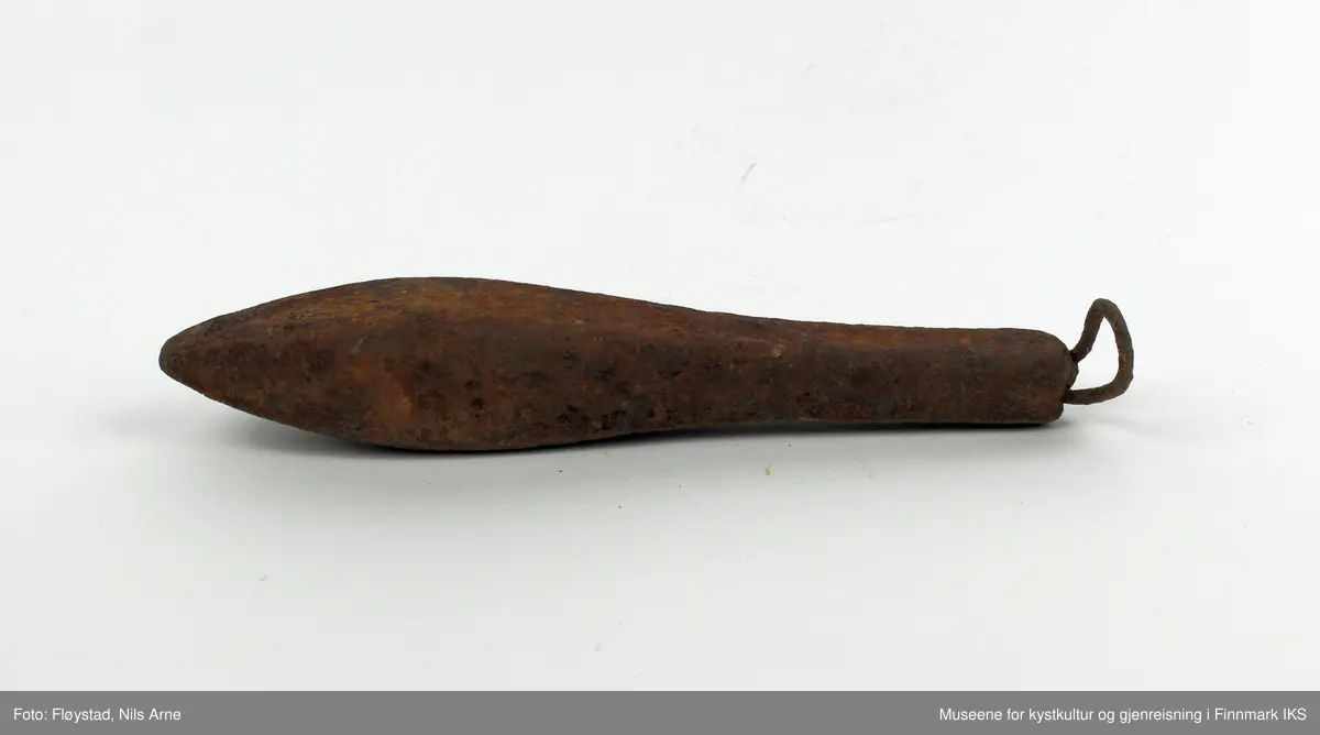 En avlang og dråpeformet jarstein med hempe. På den ene siden av jarsteinen er tallet "5" gravert, som angir vekten på steinen (500 gram).