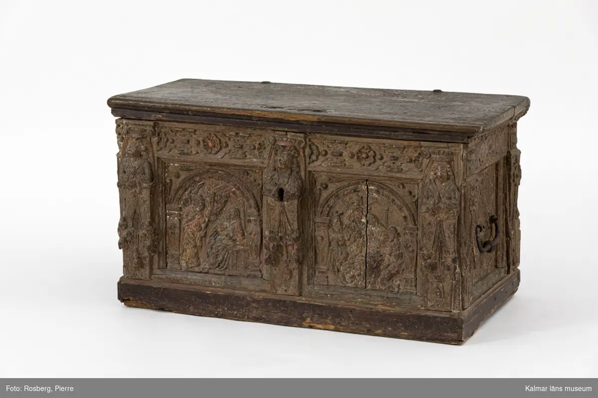 KLM 17680. Kista. Av ek. Framsidan och gavlarna är rikt skulpterade med sniderier i relief. På framsidan i vänstra fältet en framställning av bebådelsen, i det högra herdarnas tillbedjan. Kistan har rester av bemålning i bl.a. rött, vitt, gult, blått och svart. Baksidan utan sniderier samt brunmålad. Platt lock med stora målade bokstäver: Z A /. På gavlarna smidda handtag av järn. Ena gavelns spegel är lös.