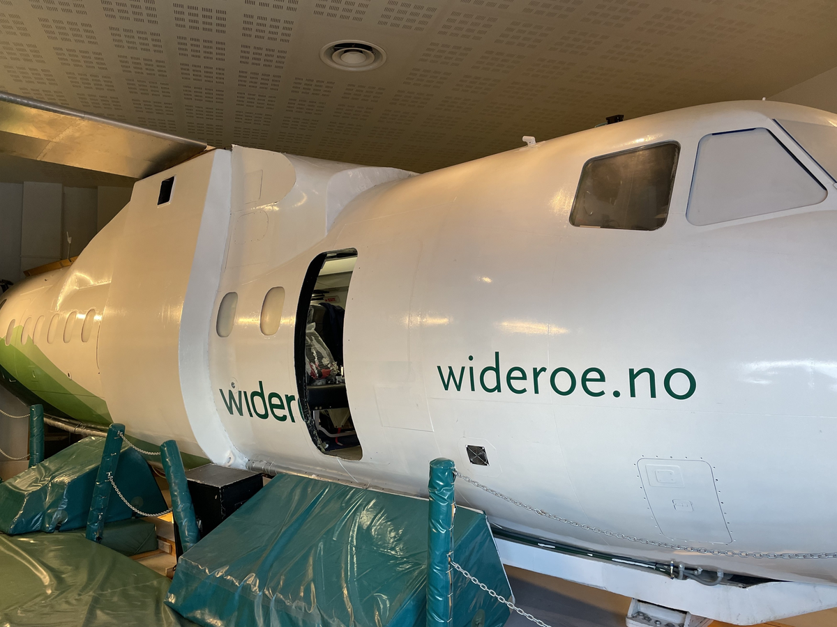 Widerøes Dash 8 kabinsimulator med fremre høyre nødutgang åpen.