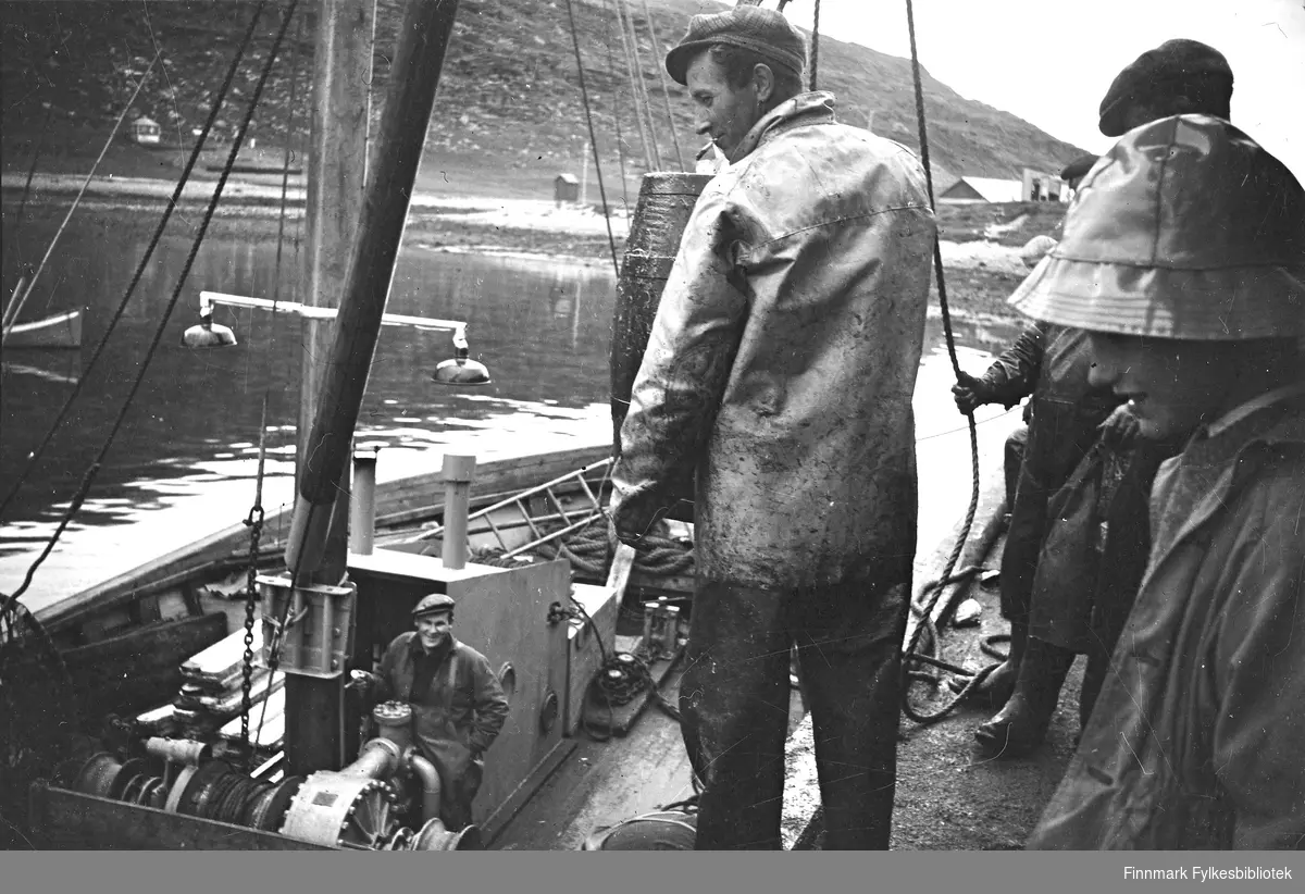 Trygve Olsen leverer fisk, Havøysund, 1952. Ukjente personer på brygga.